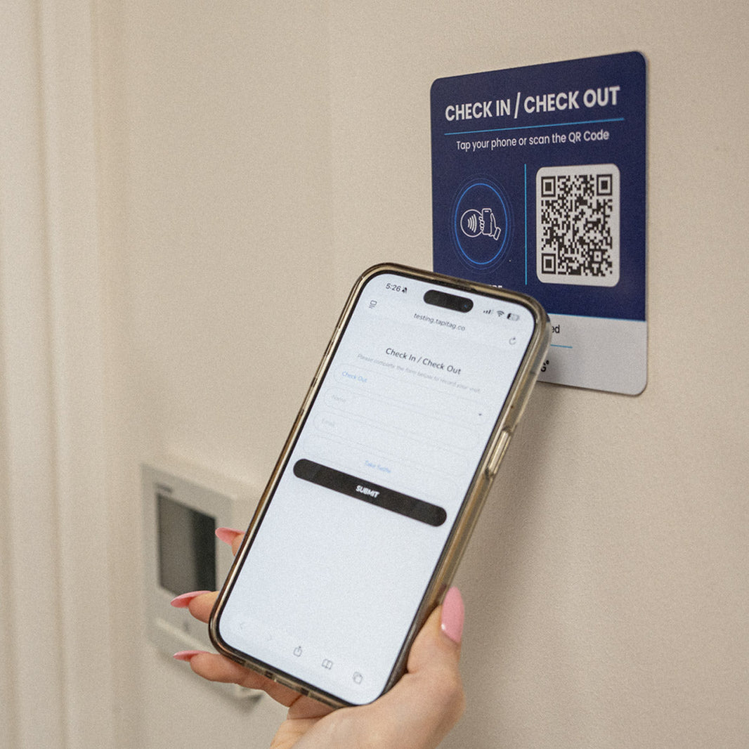 Employee using an NFC and QR clock-in system at a workplace entrance