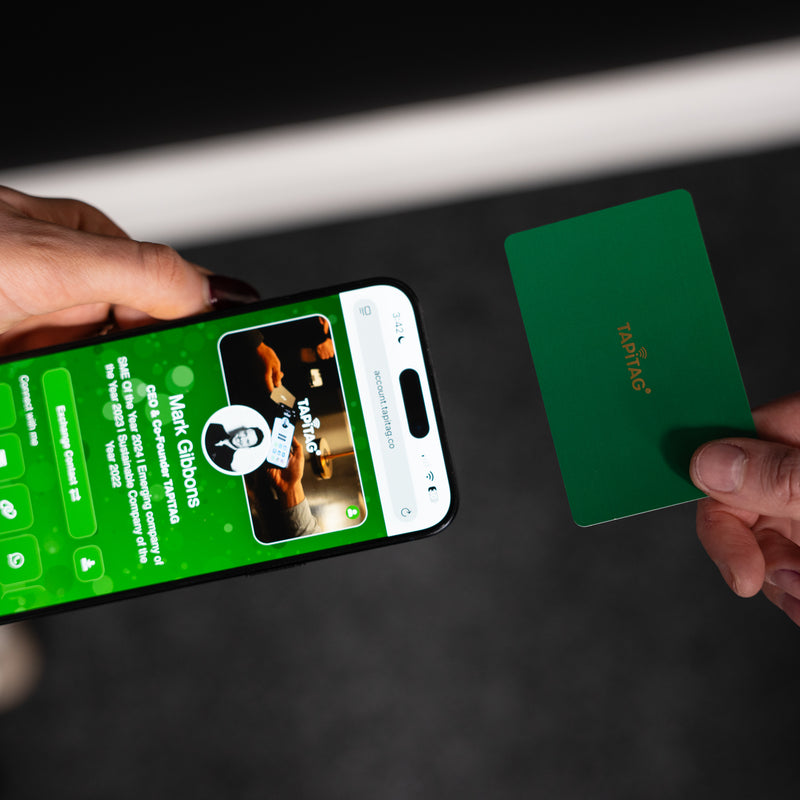 Smartphone displaying a TAPiTAG interface with a Green Digital Business  Card in the background