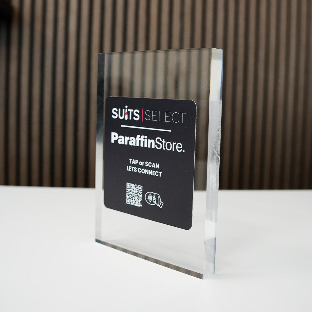 Clear acrylic sign with 'SUITS SELECT Paraffin Store' branding on a reflective surface with nfc tag
