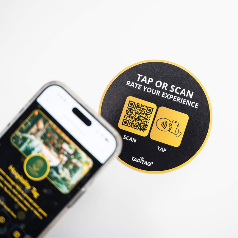 Person tapping TAPiTAG NFC hospitality tag with smartphone to access digital business profile instantly
