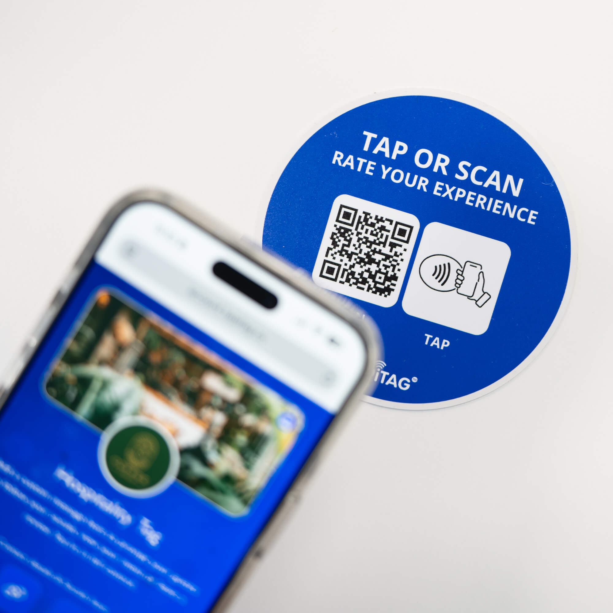 Person tapping TAPiTAG NFC hospitality tag with smartphone to access digital business profile instantly