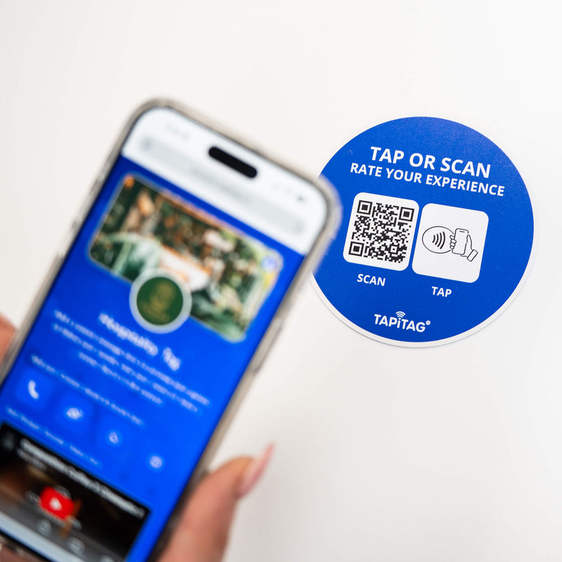 Person tapping TAPiTAG NFC hospitality tag with smartphone to access digital business profile instantly