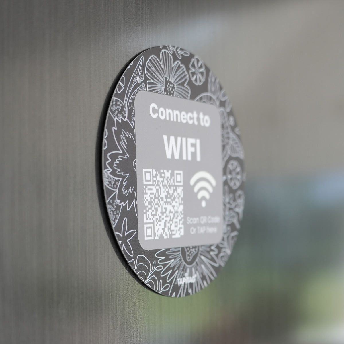 Round WiFi connection sticker with QR code on a metallic surface