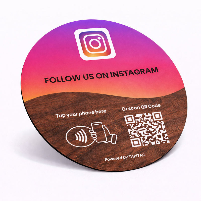 Round wooden coaster with Instagram follow prompt and QR code on a gradient background