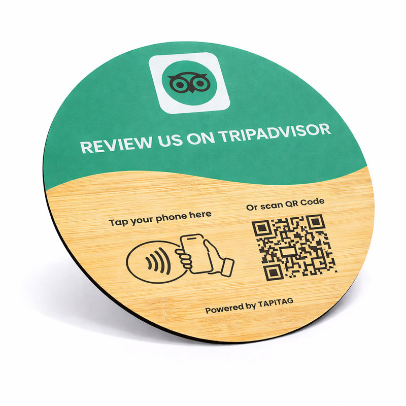 Round wooden coaster with green top and brown bottom, featuring Tripadvisor review prompt and QR code.