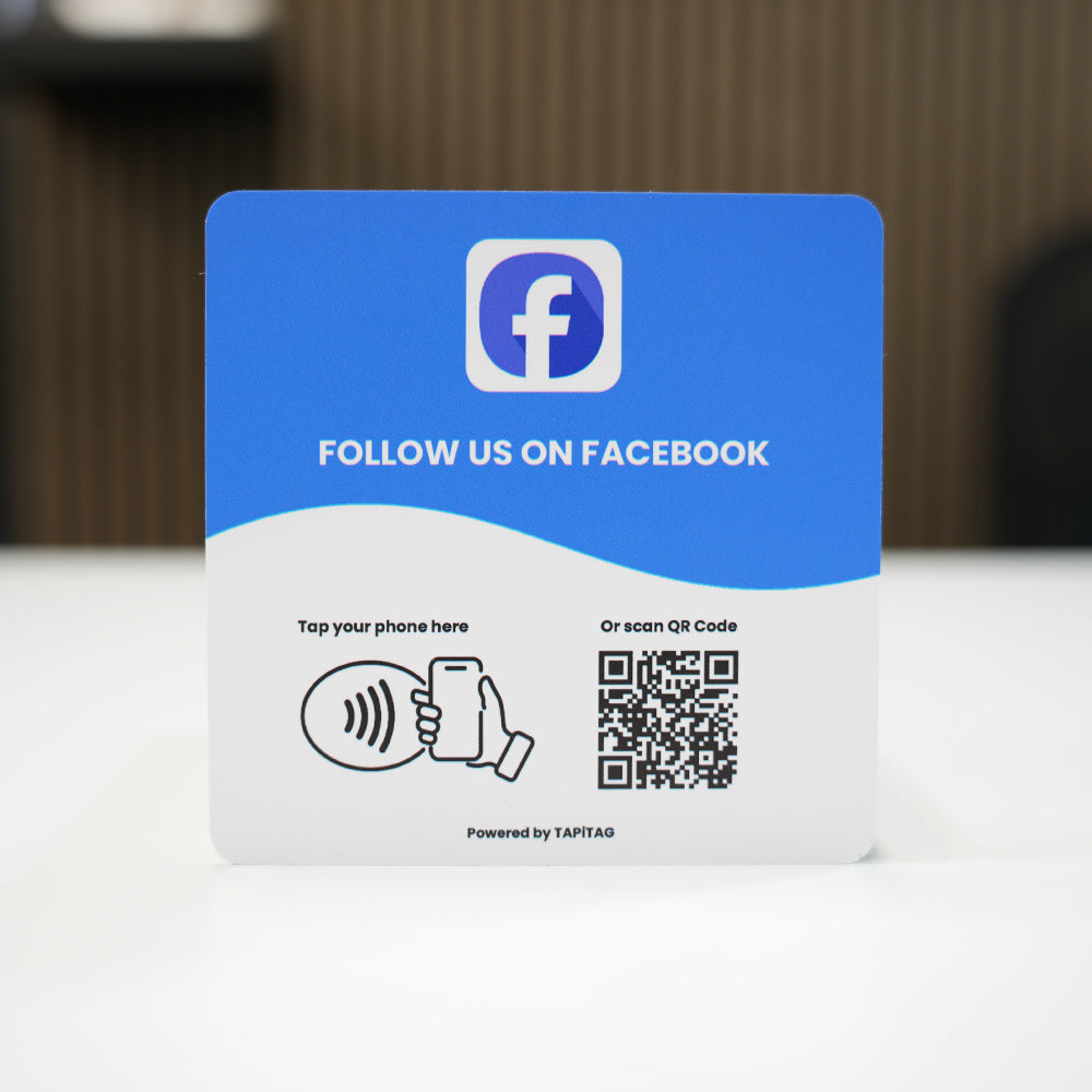 Facebook NFC tap-to-follow plate by TAPiTAG with QR code, allowing customers to tap or scan to instantly follow a business on Facebook, displayed on a white counter.