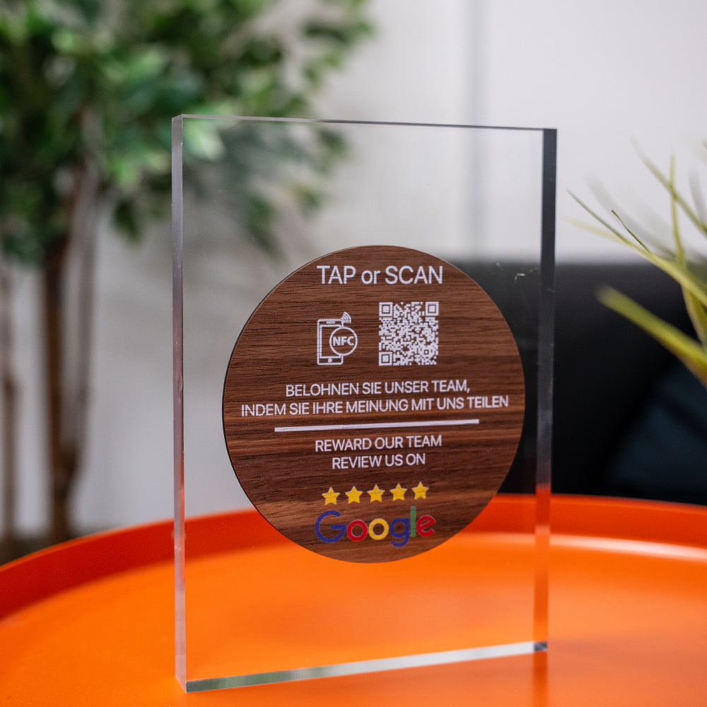 Wooden TAPiTAG NFC TAG with QR code and text on a CLEAR ACYRLIC surface