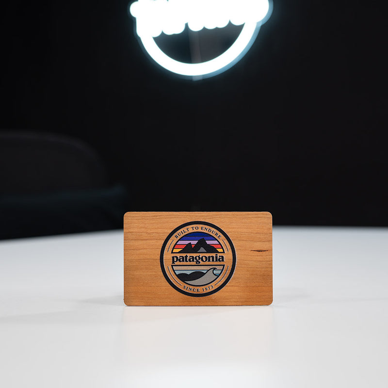 cherry Wooden Digital Business Card, also known as an NFC Business Card with  Patagonia logo on a white surface with a dark background