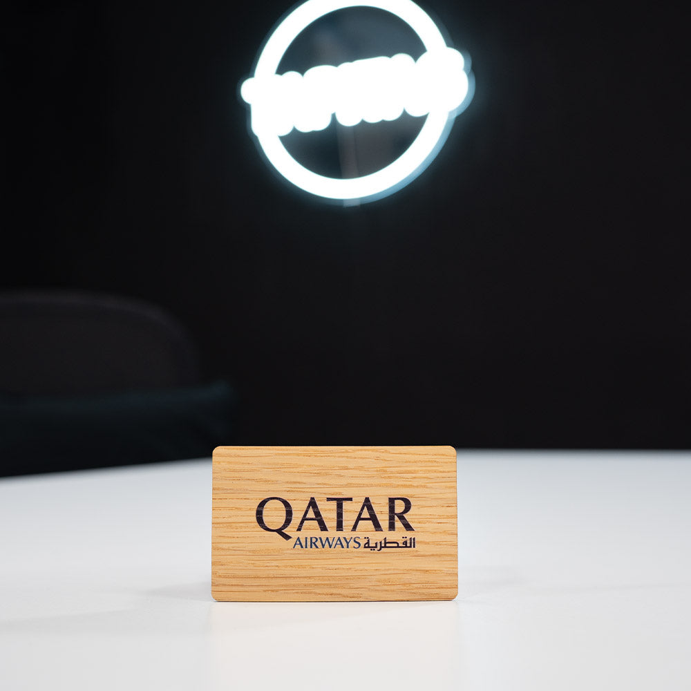 oak Wooden Digital Business Card, also known as an NFC Business Card with Qatar Airways logo on a white surface with a dark background