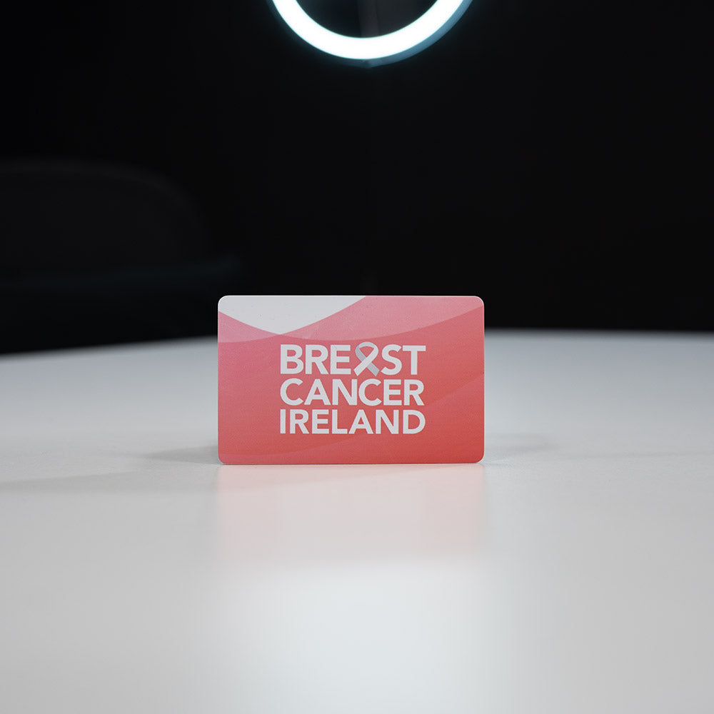 Plastic Digital Business Card, also known as an NFC Business Card Red card with 'Breast Cancer Ireland' text on a white surface