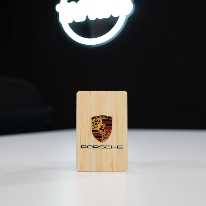 Bamboo Wooden Digital Business Card, also known as an NFC Business Card with Porsche logo on a black background