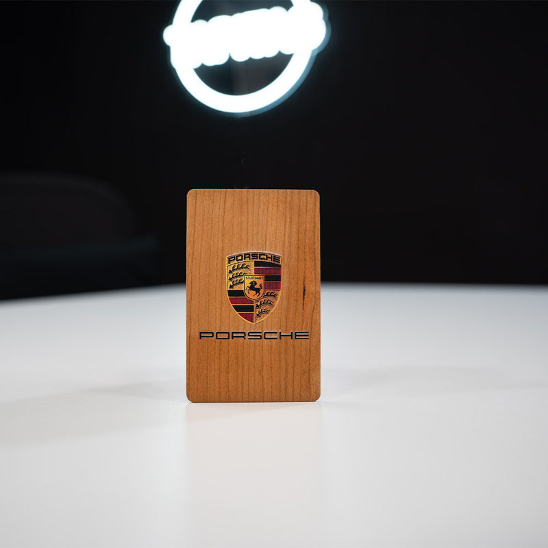 cherry Wooden Digital Business Card, also known as an NFC Business Card with  Porsche logo on a white surface with a dark background