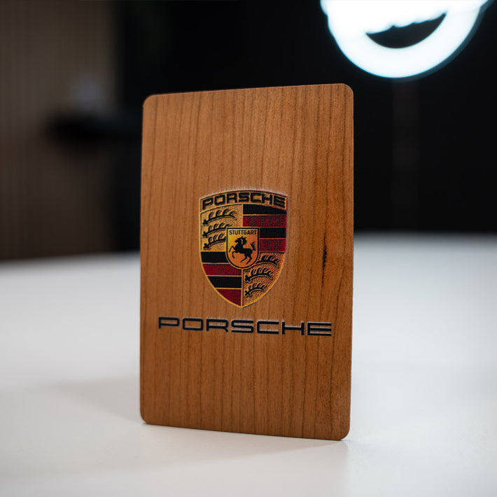 cherry Wooden Digital Business Card, also known as an NFC Business Card with  Porsche logo on a white surface