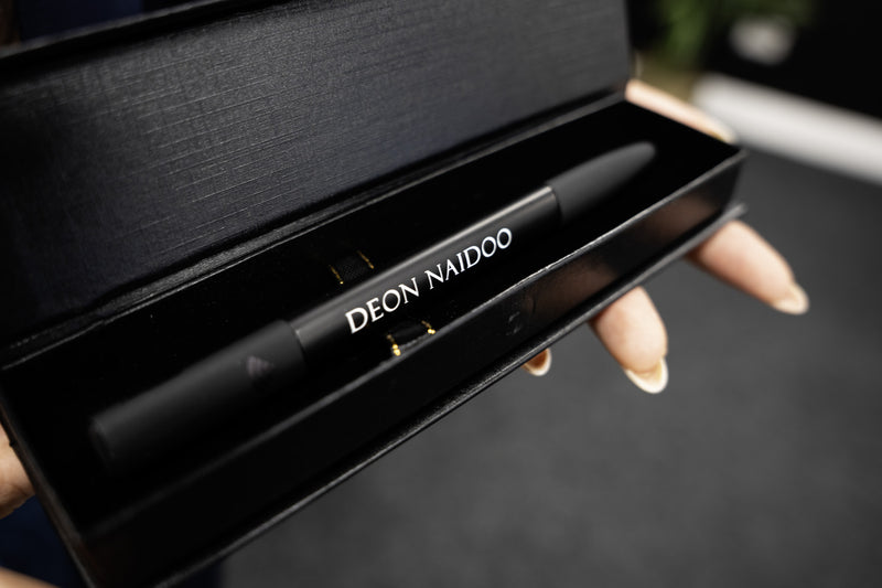 Person holding a smartphone with a contact card displayed on the screen. Phone is being held against a TAPiTAG Smart pen.