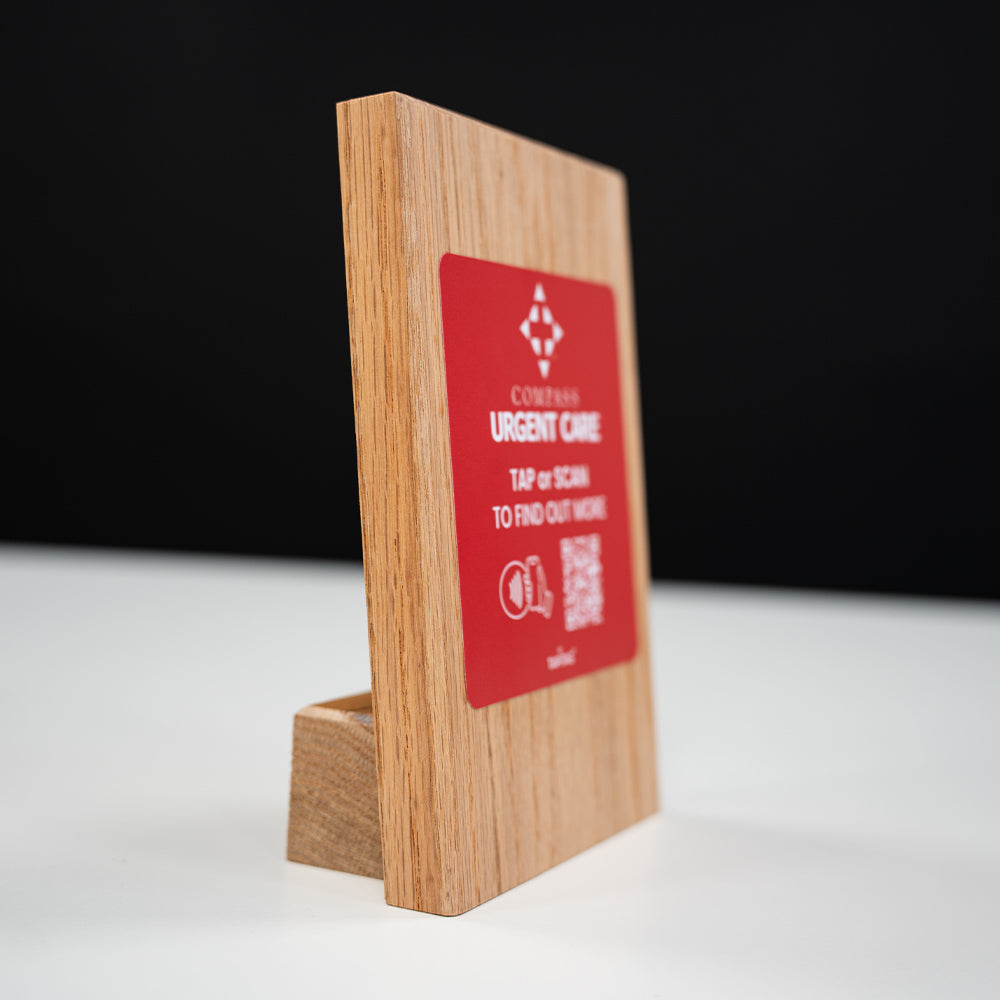 Wooden stand with a red sign displaying contact information on a white surface.