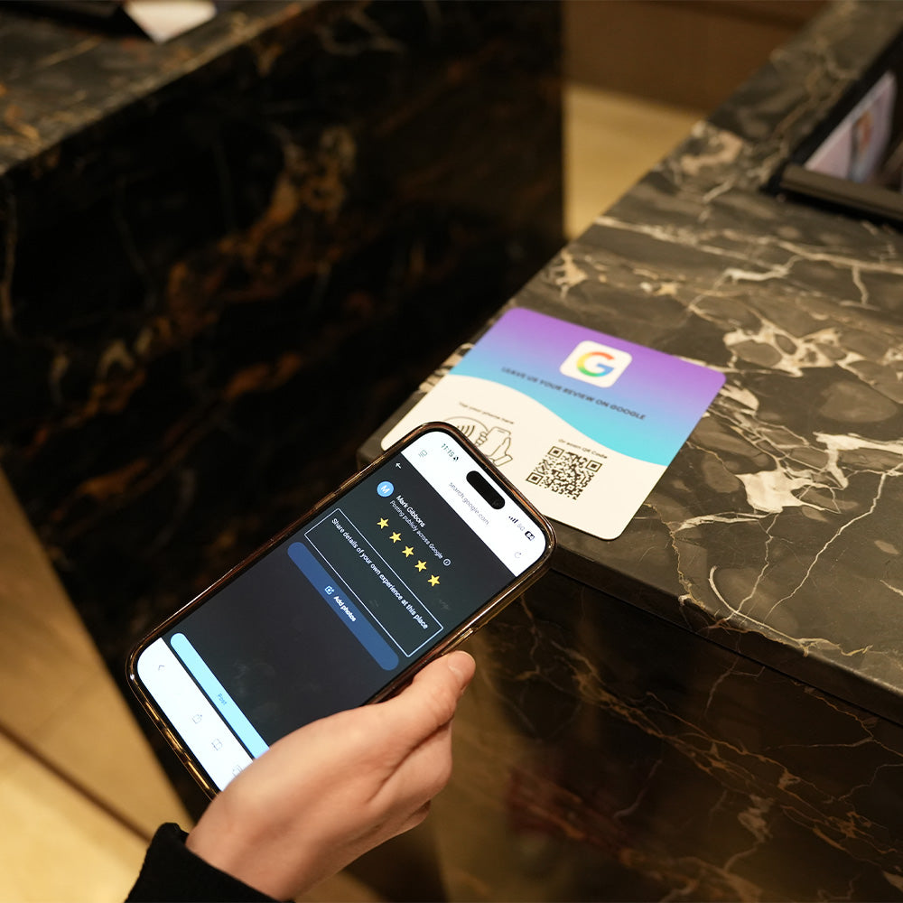 Google Review NFC review plate by TAPiTAG with QR code, allowing customers to tap or scan to instantly review a business on Google, displayed on a white counter.