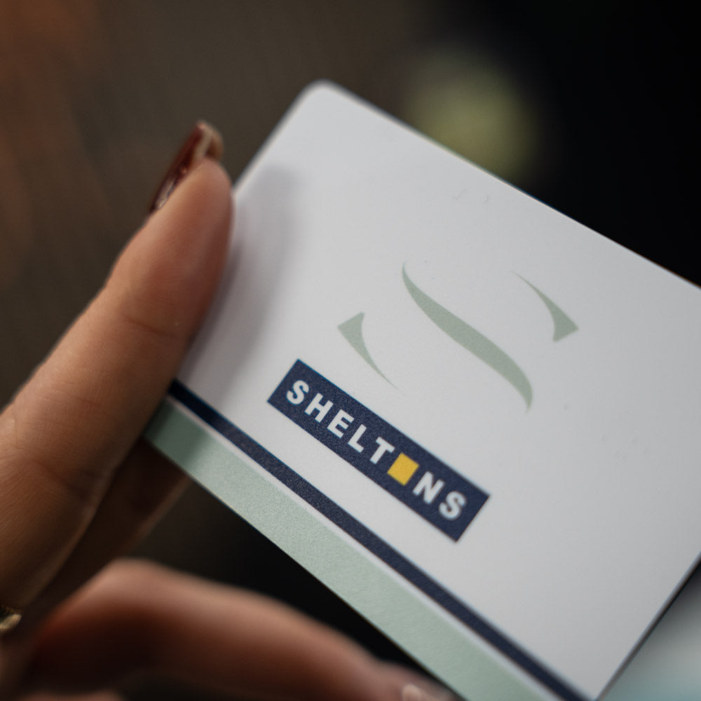 Hand holding a TAPiTAG Digital Business card box with 'SHELTONS' branding