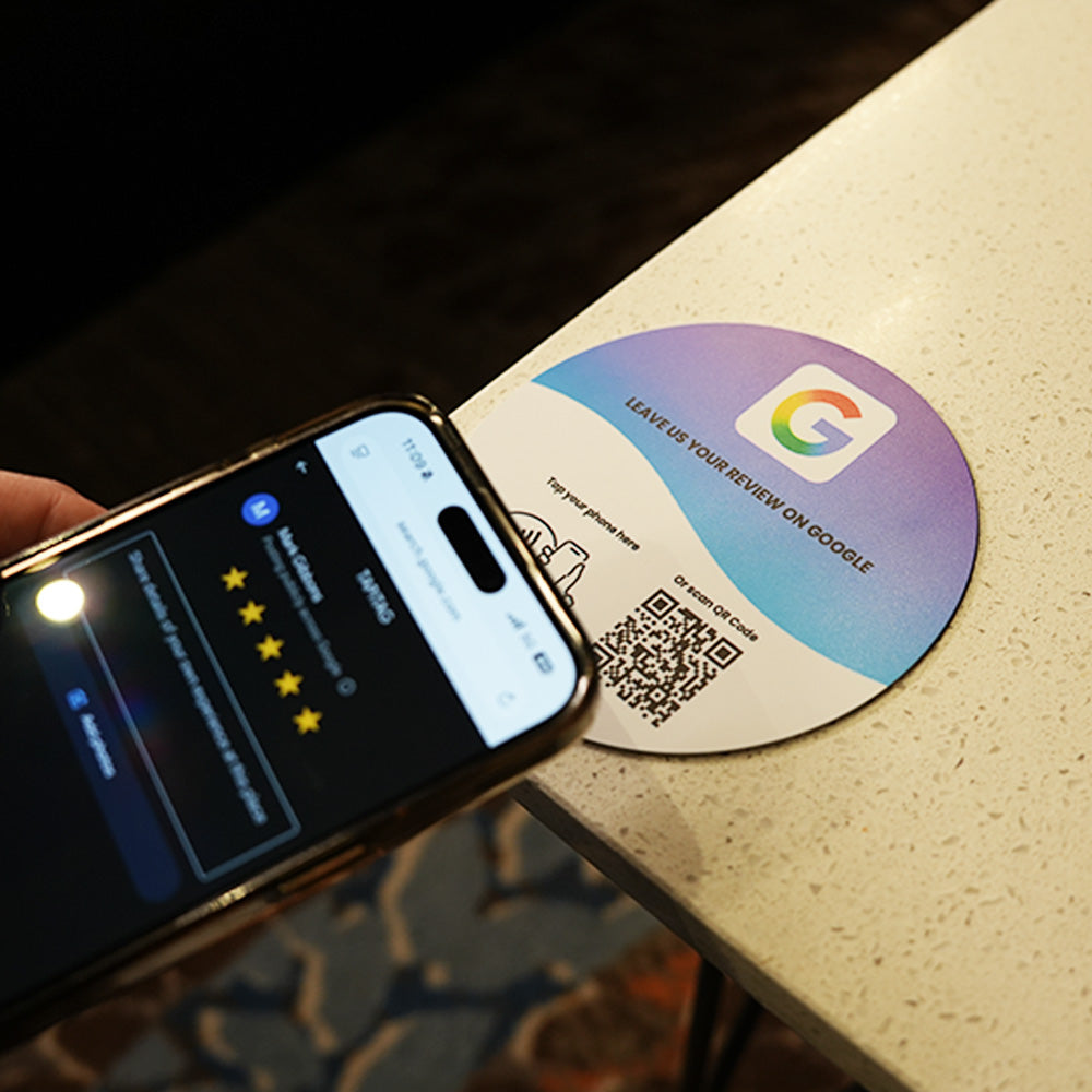 Google Review NFC review plate by TAPiTAG with QR code, allowing customers to tap or scan to instantly review a business on Google, displayed on a white counter.
