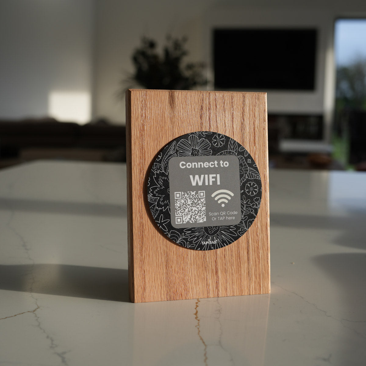 TAPiTAG wooden NFC WiFi stand on a countertop allowing guests to tap or scan a QR code to connect to WiFi instantly.