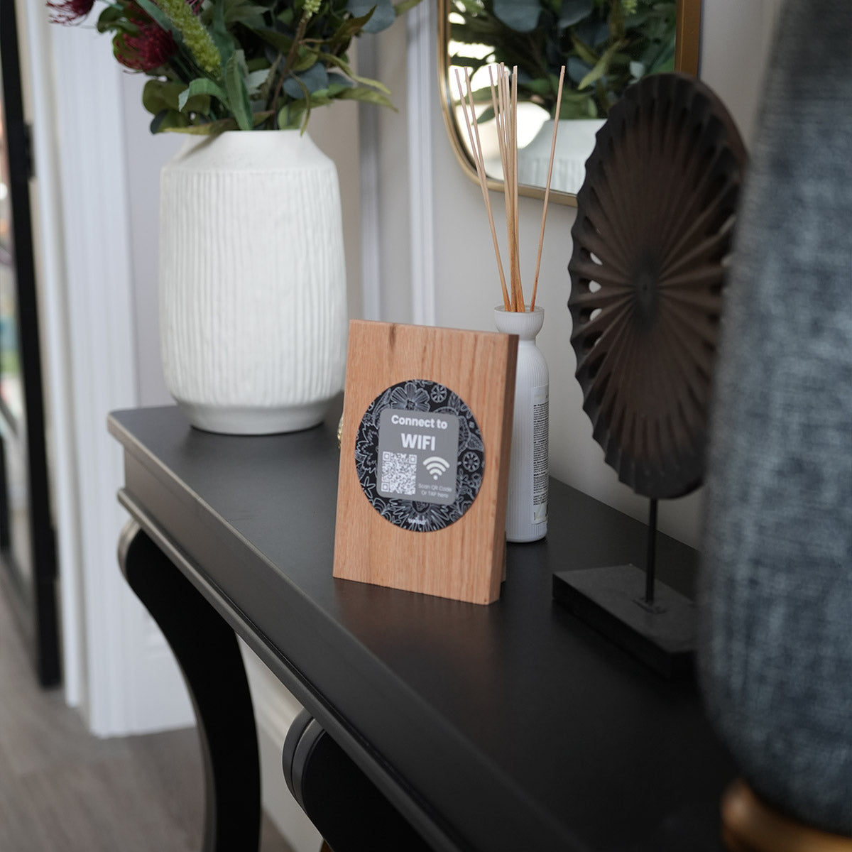 TAPiTAG wooden NFC WiFi stand on a countertop allowing guests to tap or scan a QR code to connect to WiFi instantly.