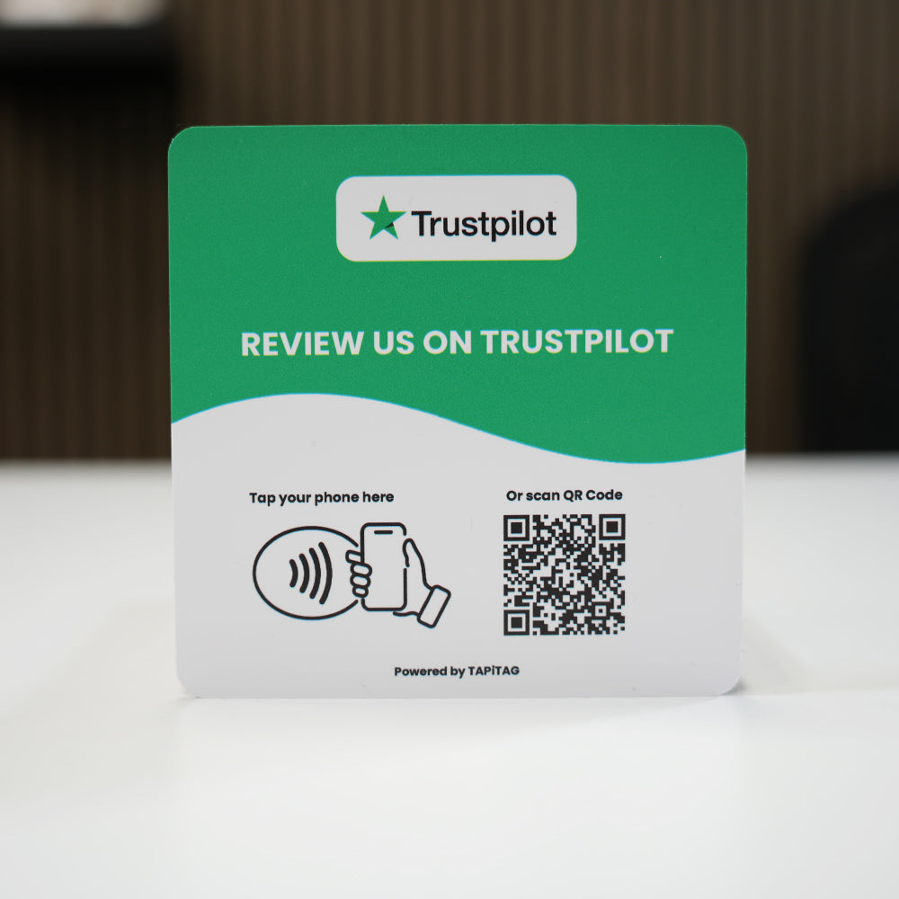 Trustpilot NFC review plate by TAPiTAG with QR code, allowing customers to tap or scan to instantly review a business on Trustpilot, displayed on a white counter.
