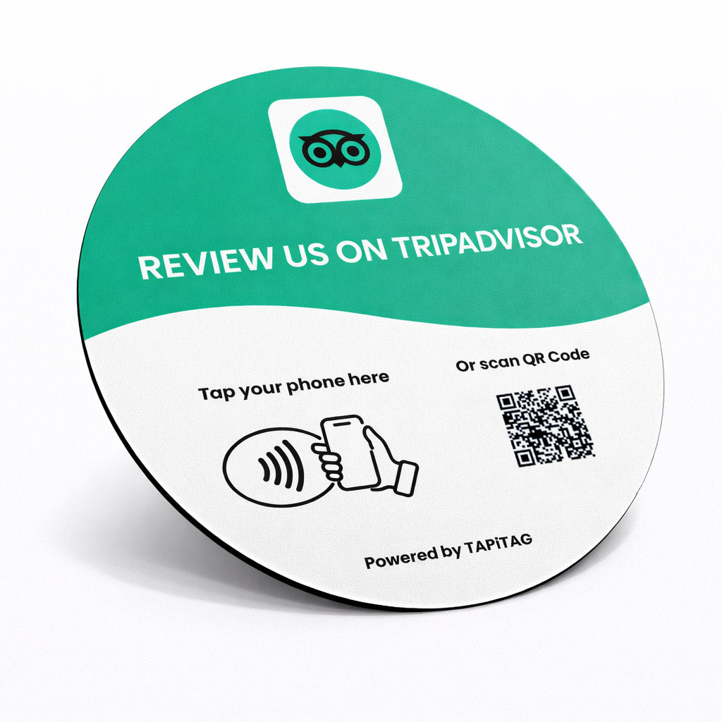 TripAdvisor NFC tap-to-follow plate by TAPiTAG with QR code, allowing customers to tap or scan to instantly follow a business on TripAdvisor, displayed on a white counter.