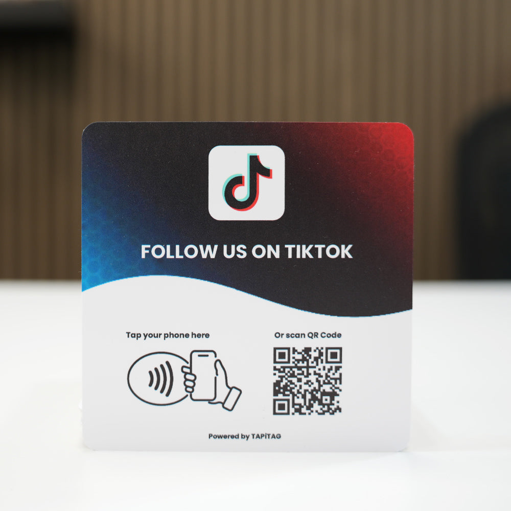 TIKTOK NFC tap-to-follow plate by TAPiTAG with QR code, allowing customers to tap or scan to instantly follow a business on TIKTOK, displayed on a white counter.