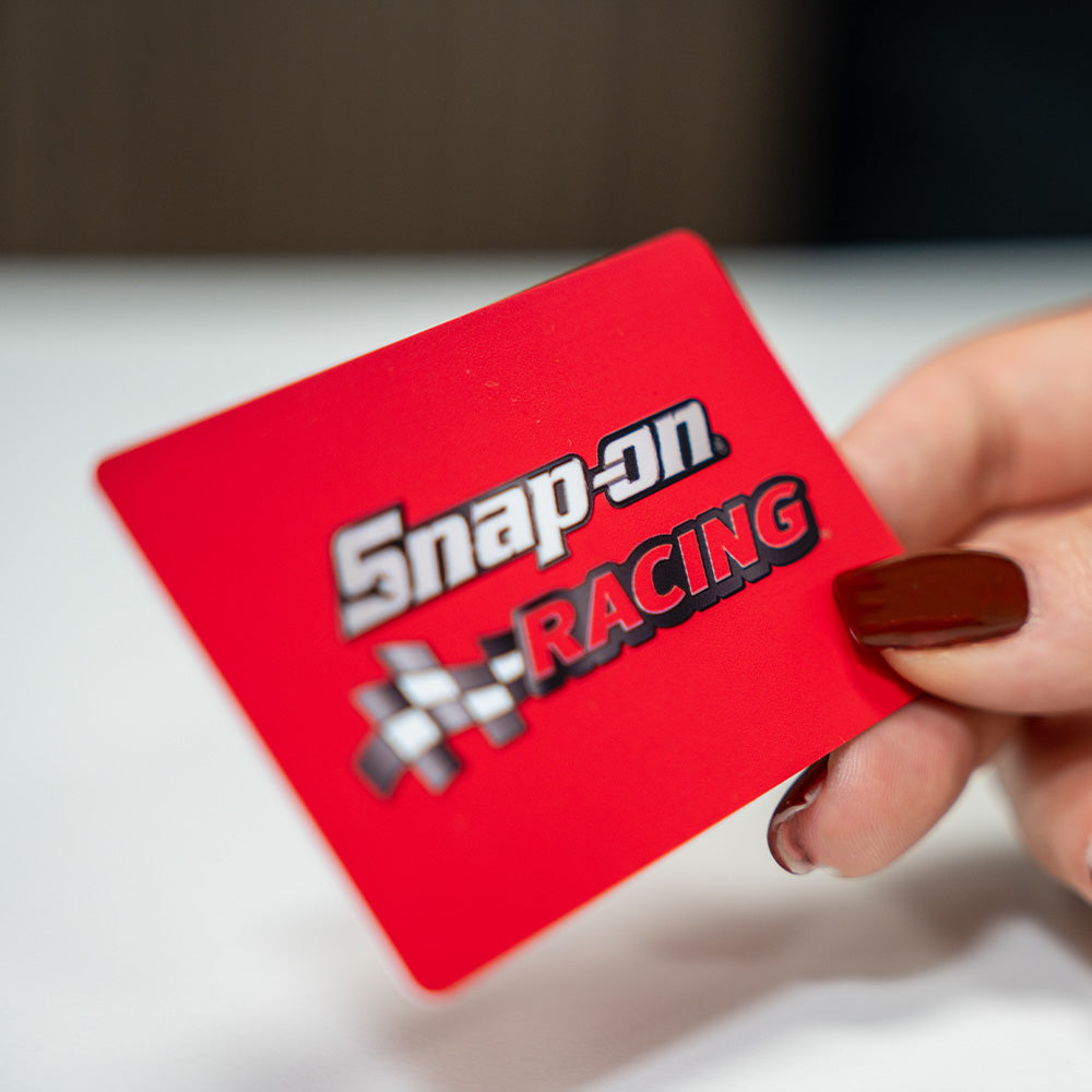 TAPiTAG Digital Business Card Red Snap-on Racing card held by a hand with dark nail polish on a light, background. NFC Business Card. 