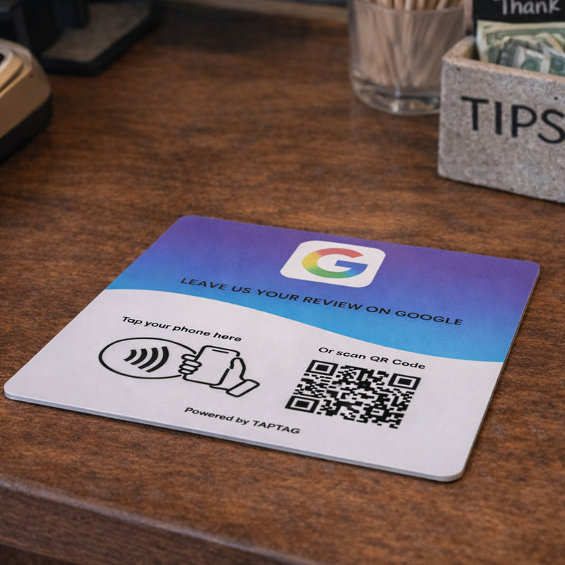 Google Review NFC review plate by TAPiTAG with QR code, allowing customers to tap or scan to instantly review a business on Google, displayed on a white counter.