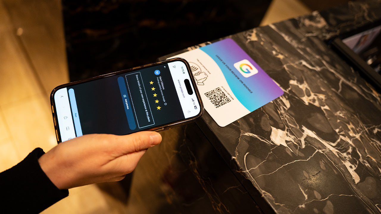 Google Review NFC review plate by TAPiTAG with QR code, allowing customers to tap or scan to instantly review a business on Google, displayed on a white counter.