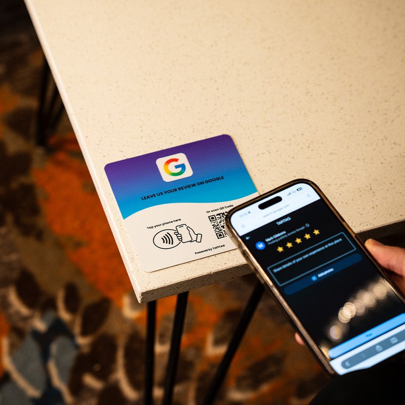 Google Review NFC review plate by TAPiTAG with QR code, allowing customers to tap or scan to instantly review a business on Google, displayed on a white counter.