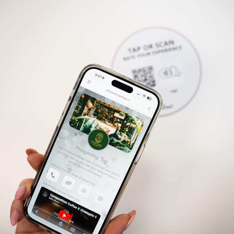 Person tapping TAPiTAG NFC hospitality tag with smartphone to access digital business profile instantly