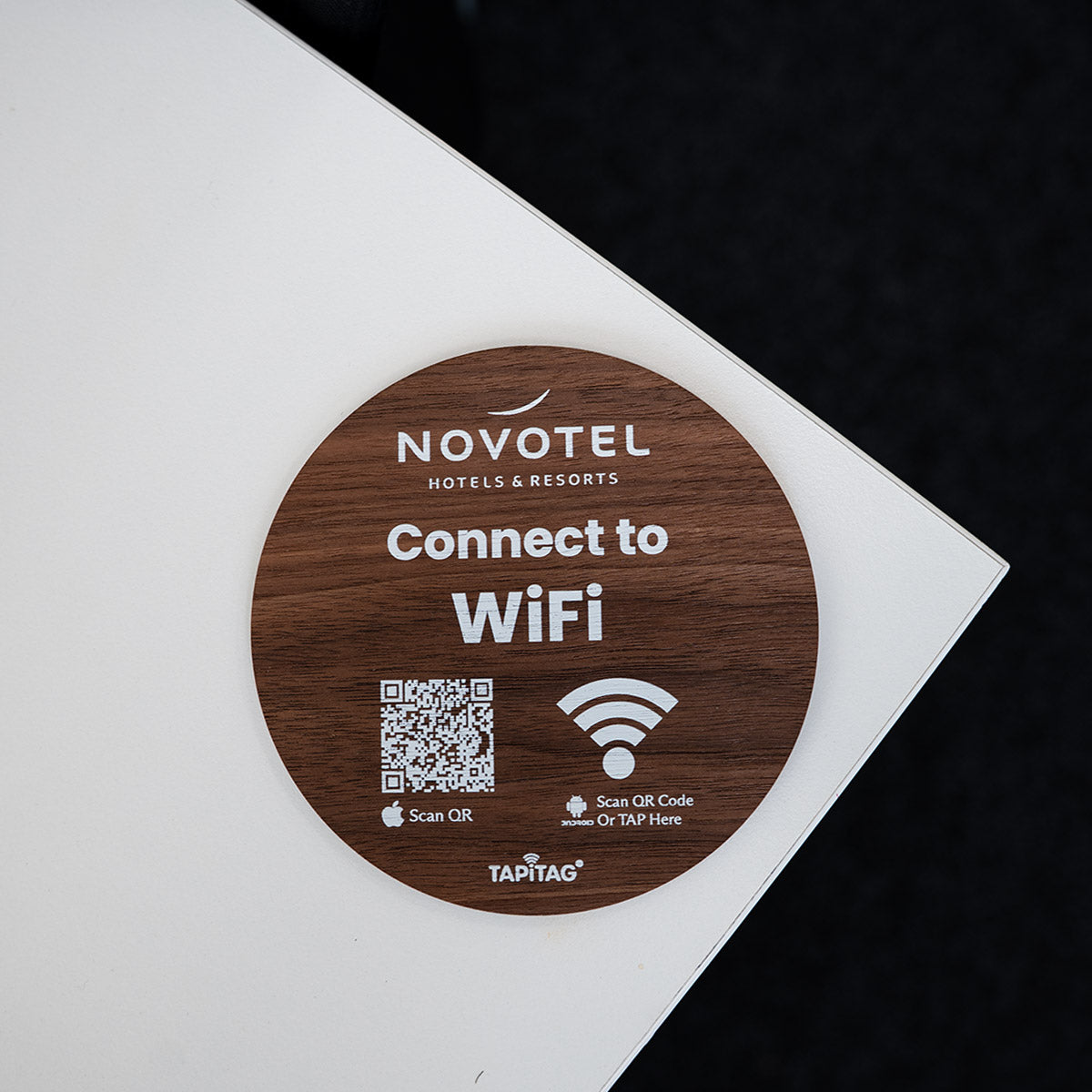  TAPiTAG wifi porter Novotel WiFi sign with QR code on a wooden coaster