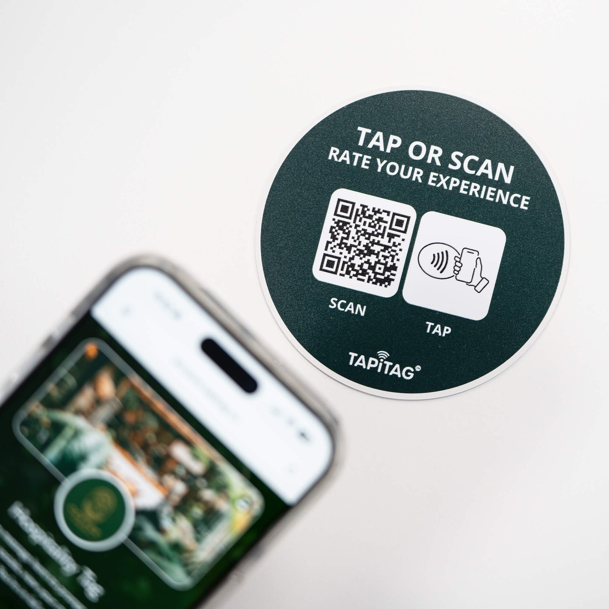 Person tapping TAPiTAG NFC hospitality tag with smartphone to access digital business profile instantly