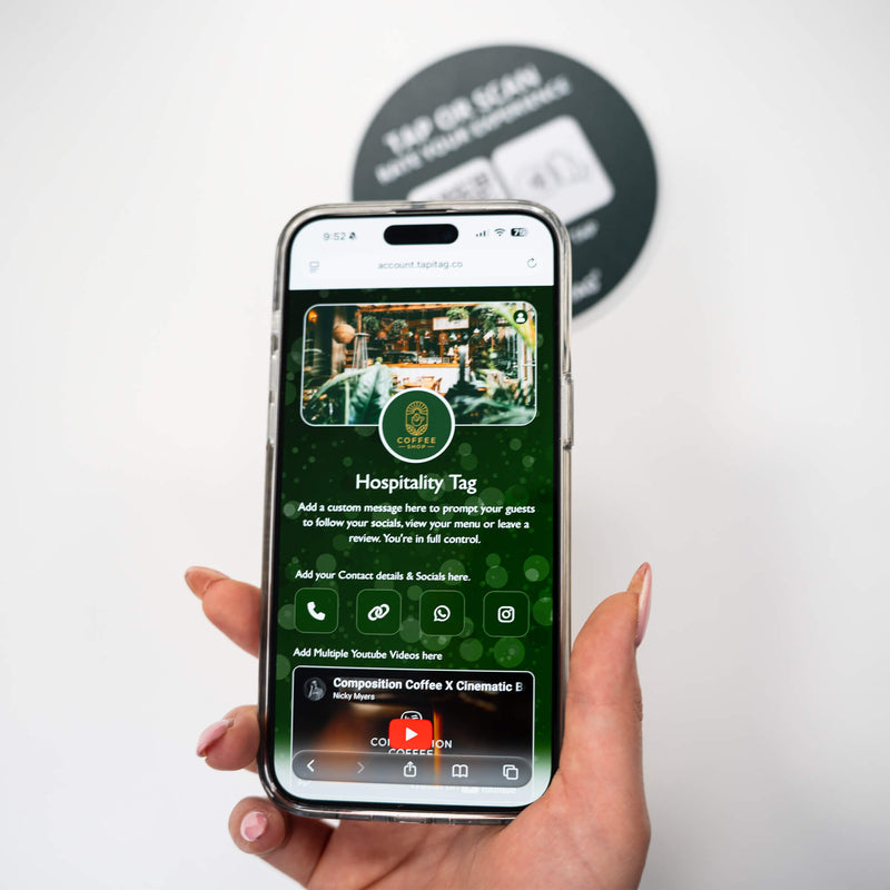 Person tapping TAPiTAG NFC hospitality tag with smartphone to access digital business profile instantly