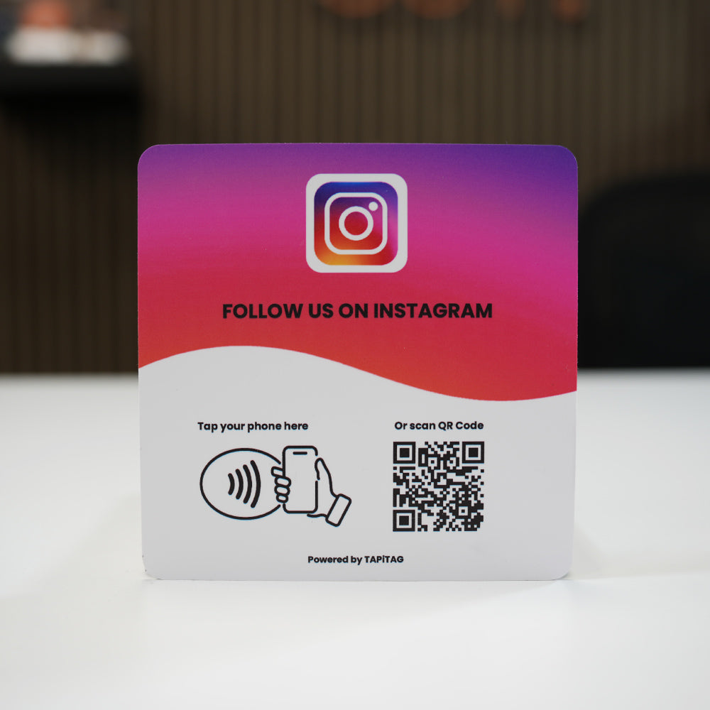 Instagram NFC tap-to-follow plate by TAPiTAG with QR code, allowing customers to tap or scan to instantly follow a business on Instagram, displayed on a white counter.