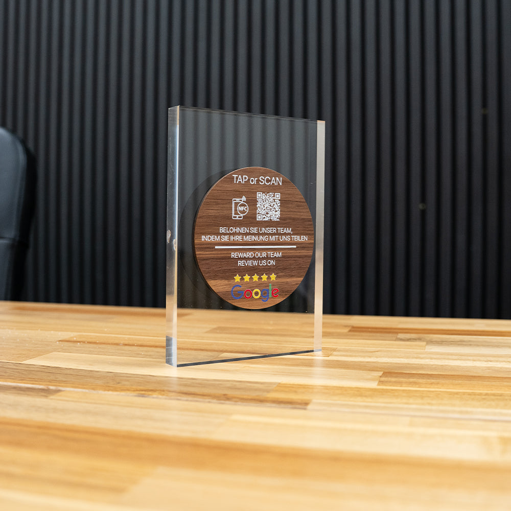 Wooden TAPiTAG NFC TAG with QR code and text on a CLEAR ACYRLIC surface