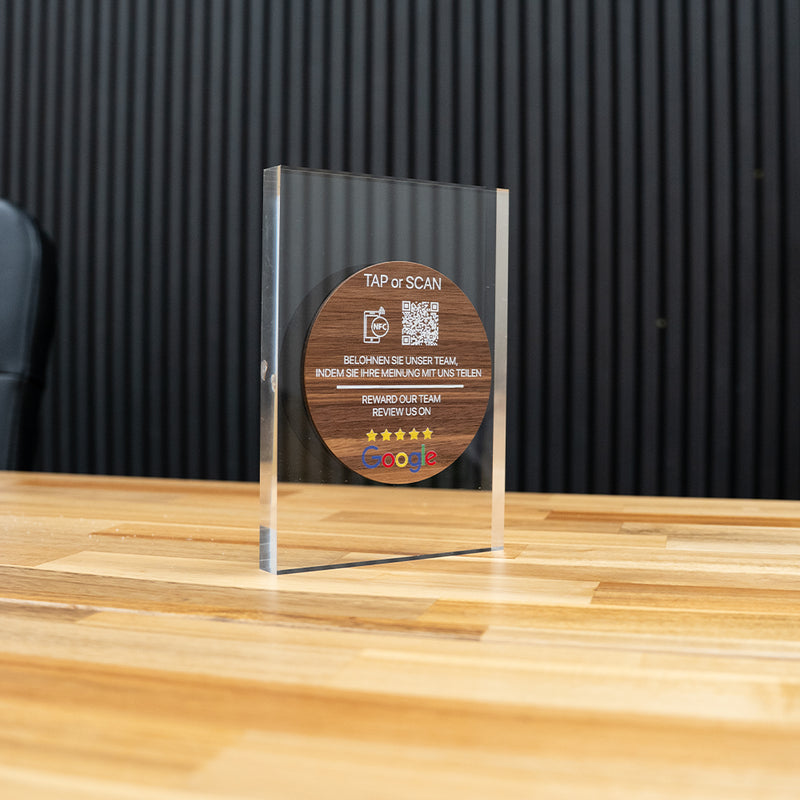 Wooden TAPiTAG NFC TAG with QR code and text on a CLEAR ACYRLIC surface