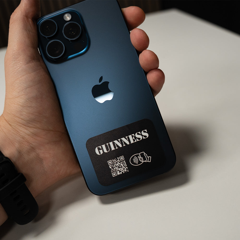 Person holding a blue phone case with a QR code and 'Guinness' branding. TAPiTAG NFC QR MINICARD NFC-Enabled Digital Business Card