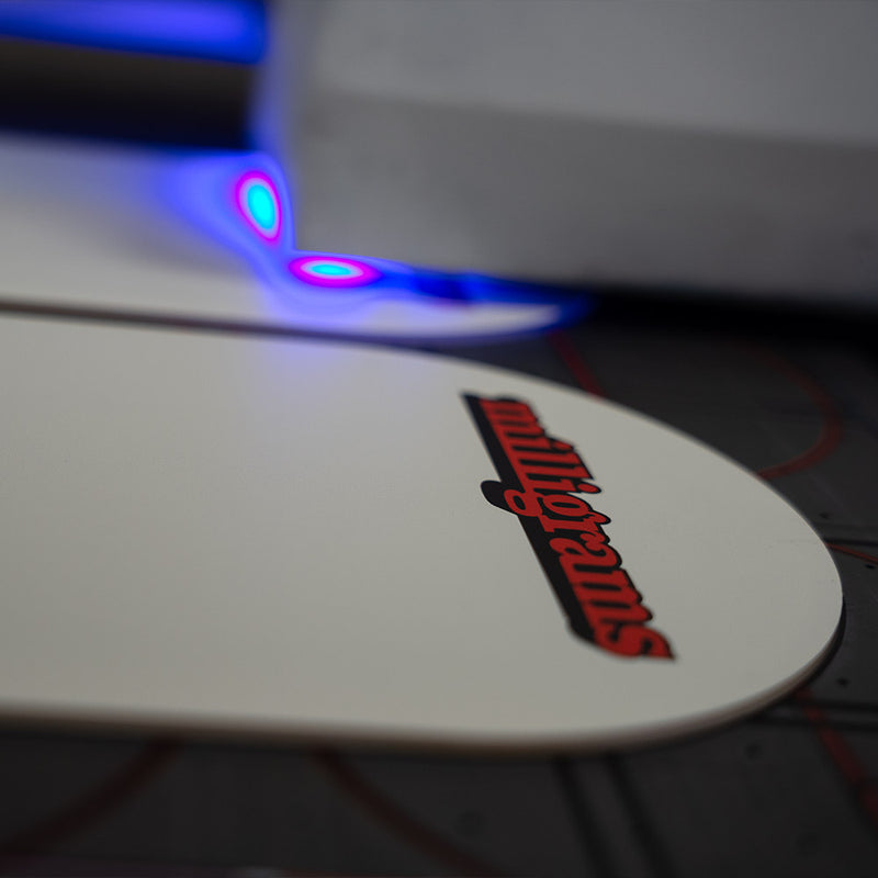 Close-up of a white surface with a red 'milligrammus' logo and colorful LED lights. UV Printer