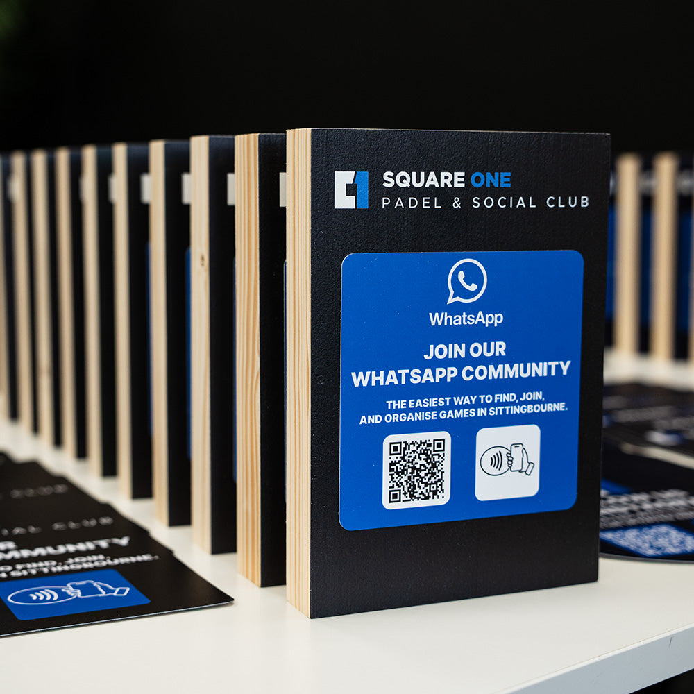 Promotional TAPiTAG Smart Display stand for Square One Padel & Social Club with WhatsApp community call-to-action on a table.