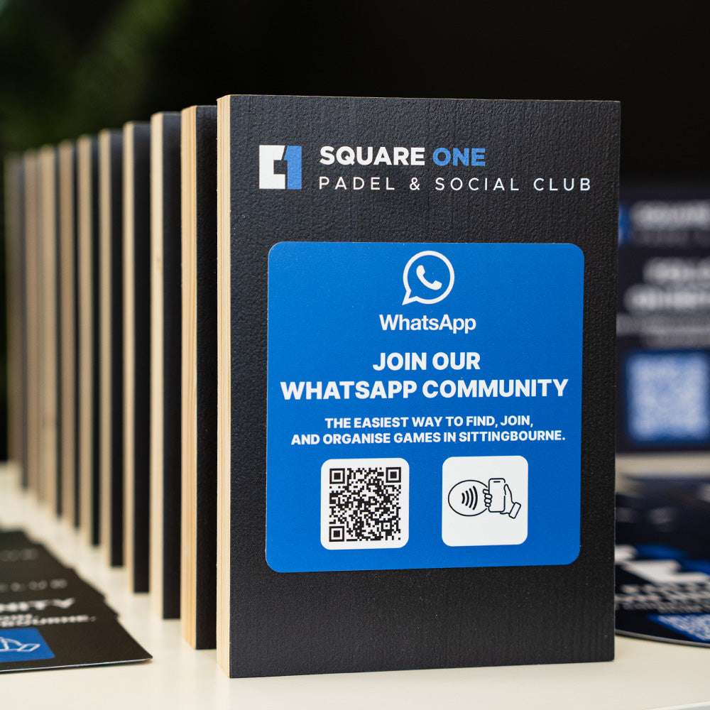 Promotional TAPiTAG Smart Display stand for Square One Padel & Social Club with WhatsApp community call-to-action on a table.
