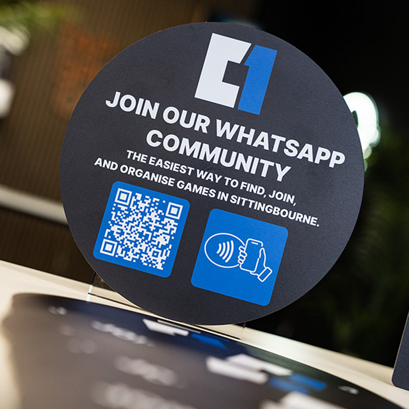 Round Blue NFC TAG TAPiTAG with WhatsApp community invitation and QR code on a blurred background